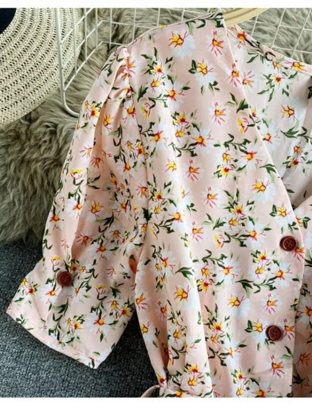 Pink floral v-neck midi dress with short puff sleeves and button details.