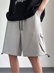 Gray perforated chino shorts with drawstring waist and adjustable hem.