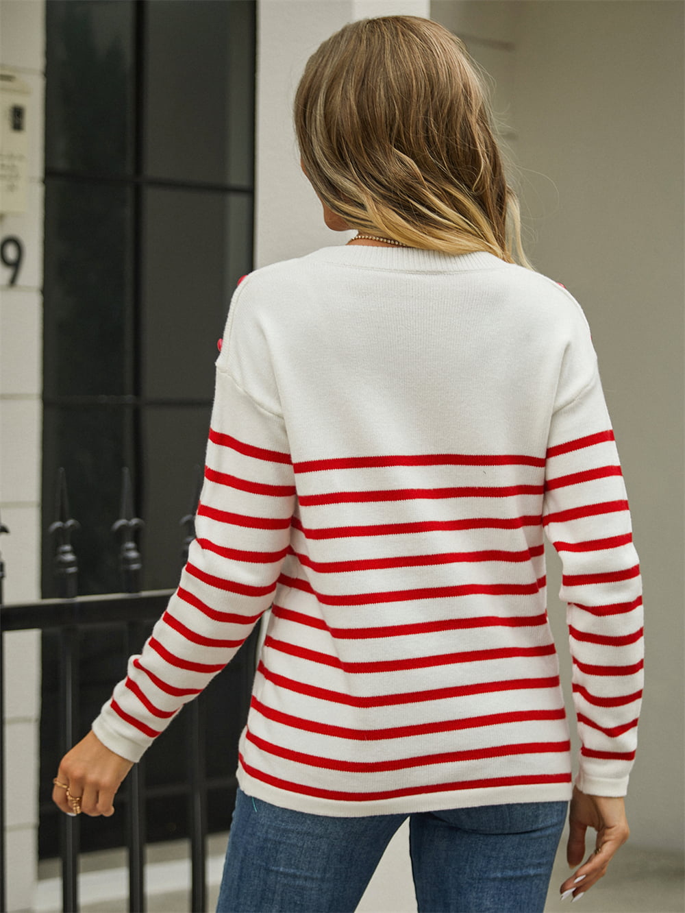 White and red striped acrylic sweater with shoulder buttons and a crew neck.
