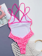 Hot pink leopard print one-piece swimsuit with strappy back and ruched detail.