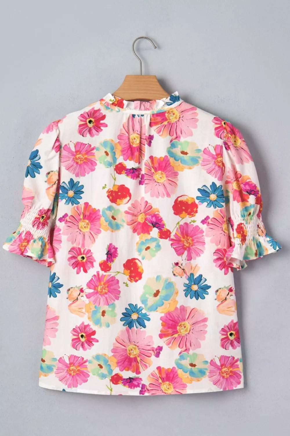 Vibrant floral print cotton blend shirt with ruched short sleeves and ruffled neckline.