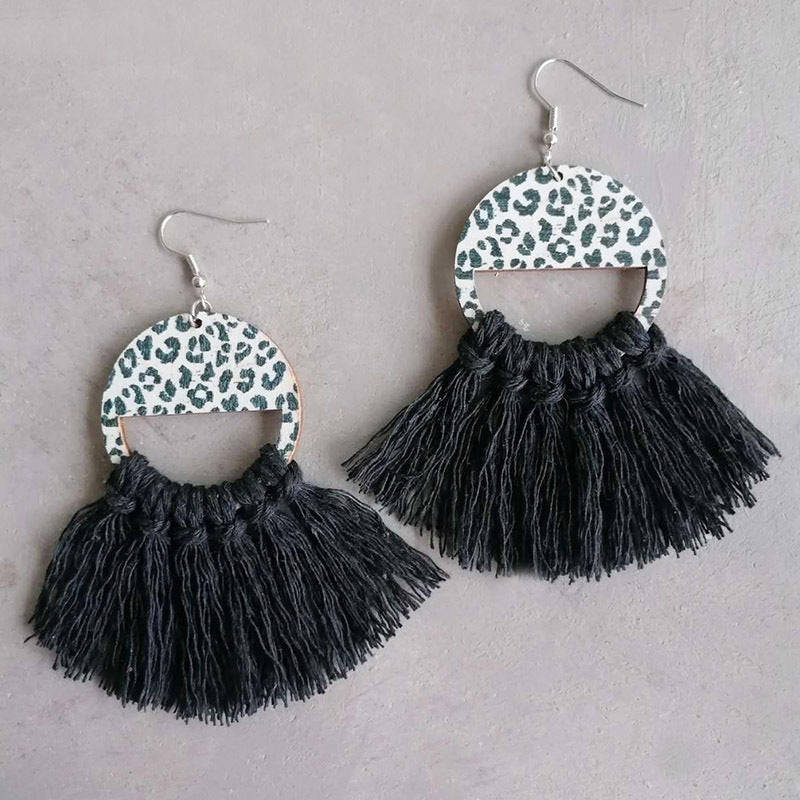 Leopard print tassel earrings with black fringe and half-circle wooden tops.