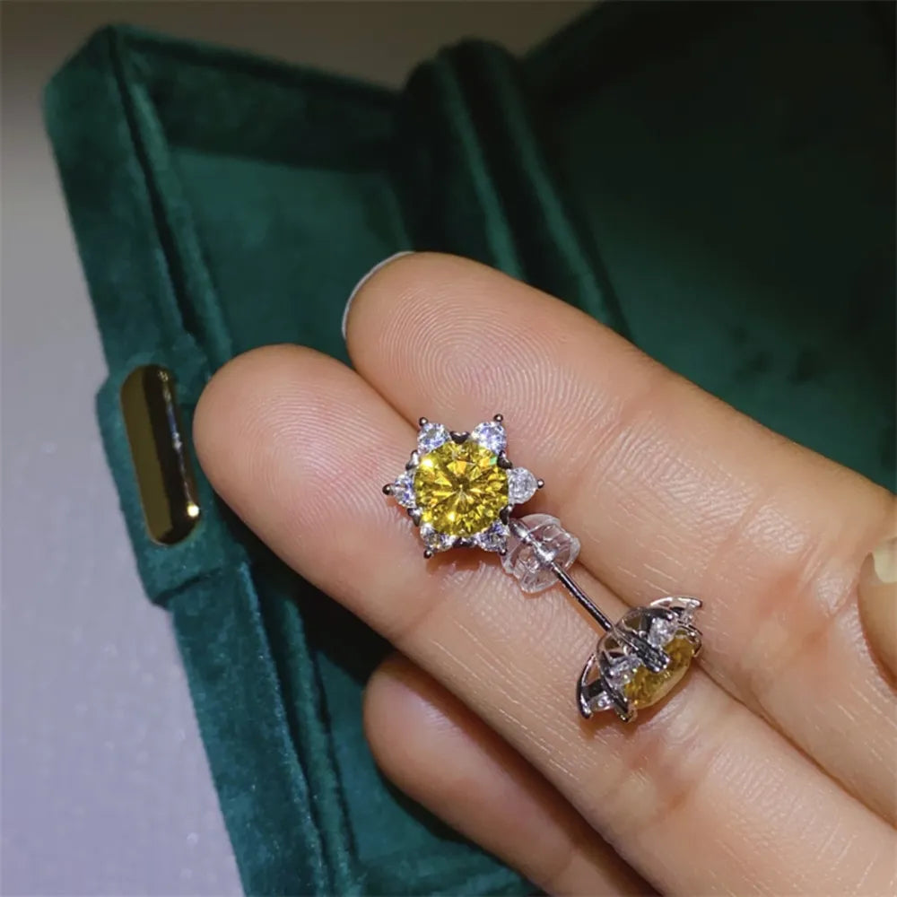 Golden sunburst moissanite stud earrings in silver with clear backing.