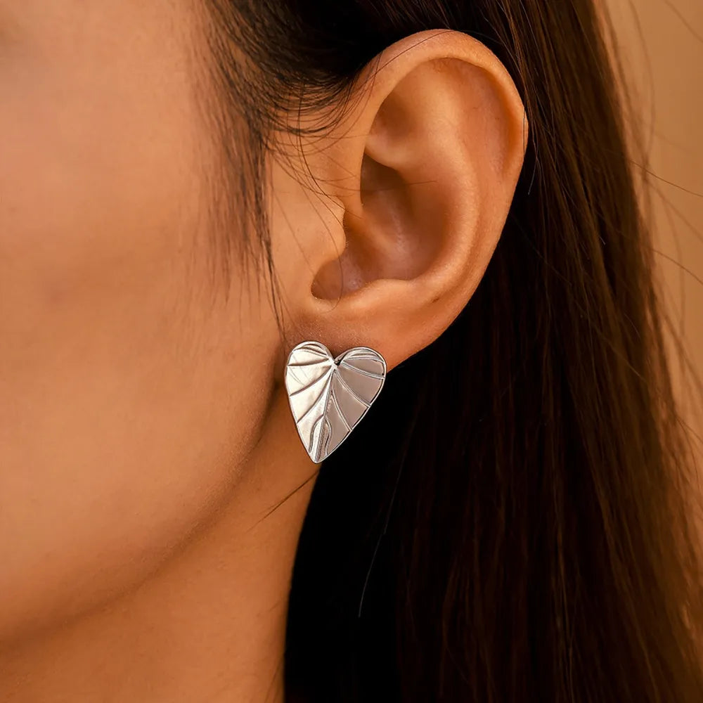 Silver heartleaf stud earrings with detailed vein texture.