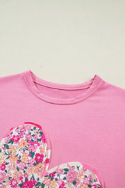 Pink cotton t-shirt with floral heart patch detail and crew neck.