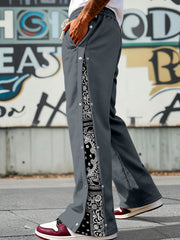 Men's dark gray wide leg sweatpants with side snaps and paisley print detail.