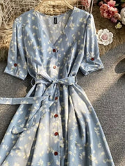 Light blue floral v-neck midi dress with button front and belted waist.