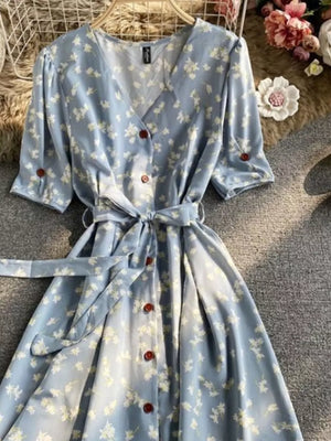 Light blue floral v-neck midi dress with button front and belted waist.