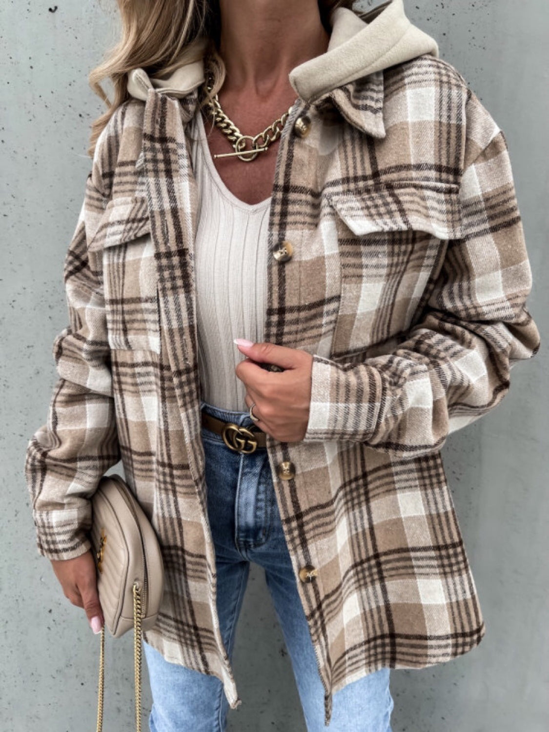 Oversized plaid shacket with attached hood in camel and white, featuring button front and chest pockets.