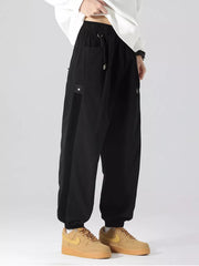 Black oversized cargo joggers with drawstring and side stripe detail.
