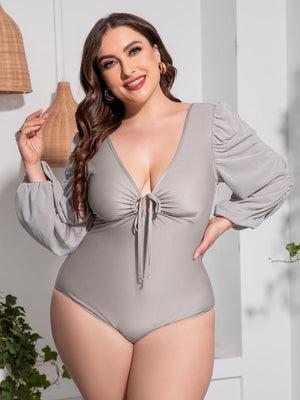 Light gray one-piece swimsuit with tie-front, deep V-neck, and ruched balloon sleeves.