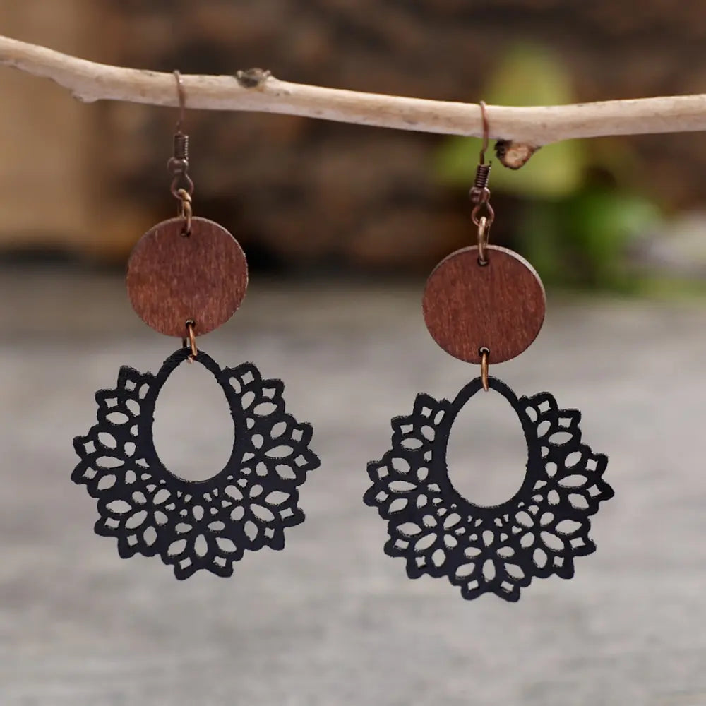 Black laser-cut wooden drop earrings with floral pattern and wood circle detail.