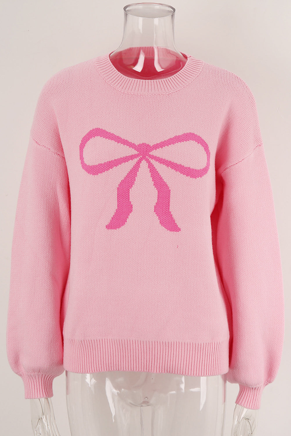 Blush pink acrylic sweater with a graphic pink bow intarsia pattern and crew neck.