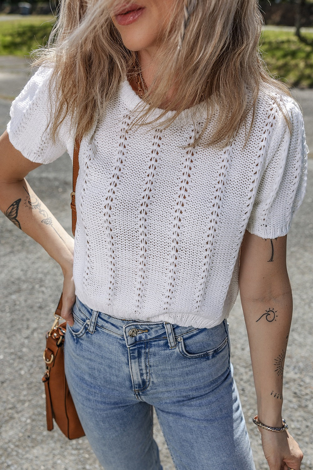 White eyelet knit puff sleeve top with a textured pattern.
