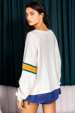White raglan sleeve sweatshirt with green and gold stripe detail on sleeves.