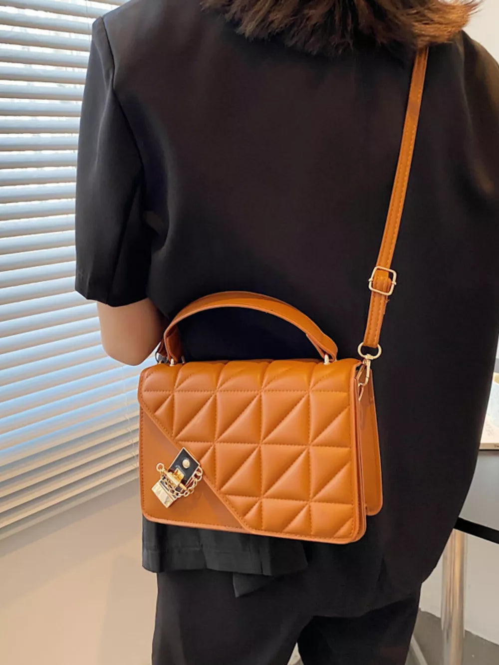 Caramel diamond quilted PU leather crossbody bag with gold chain detail.