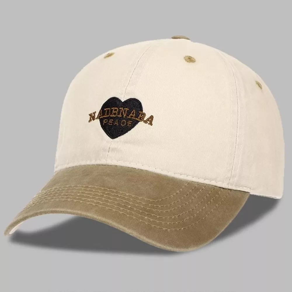 Vintage-washed baseball cap in cream and tan with embroidered heart and text detail.