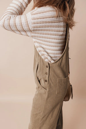 Camel corduroy wide-leg overalls with button detail and pockets, styled with a striped knit top.