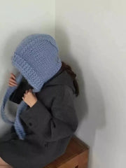 Blue wool earflap beanie hat with chunky knit and ties.