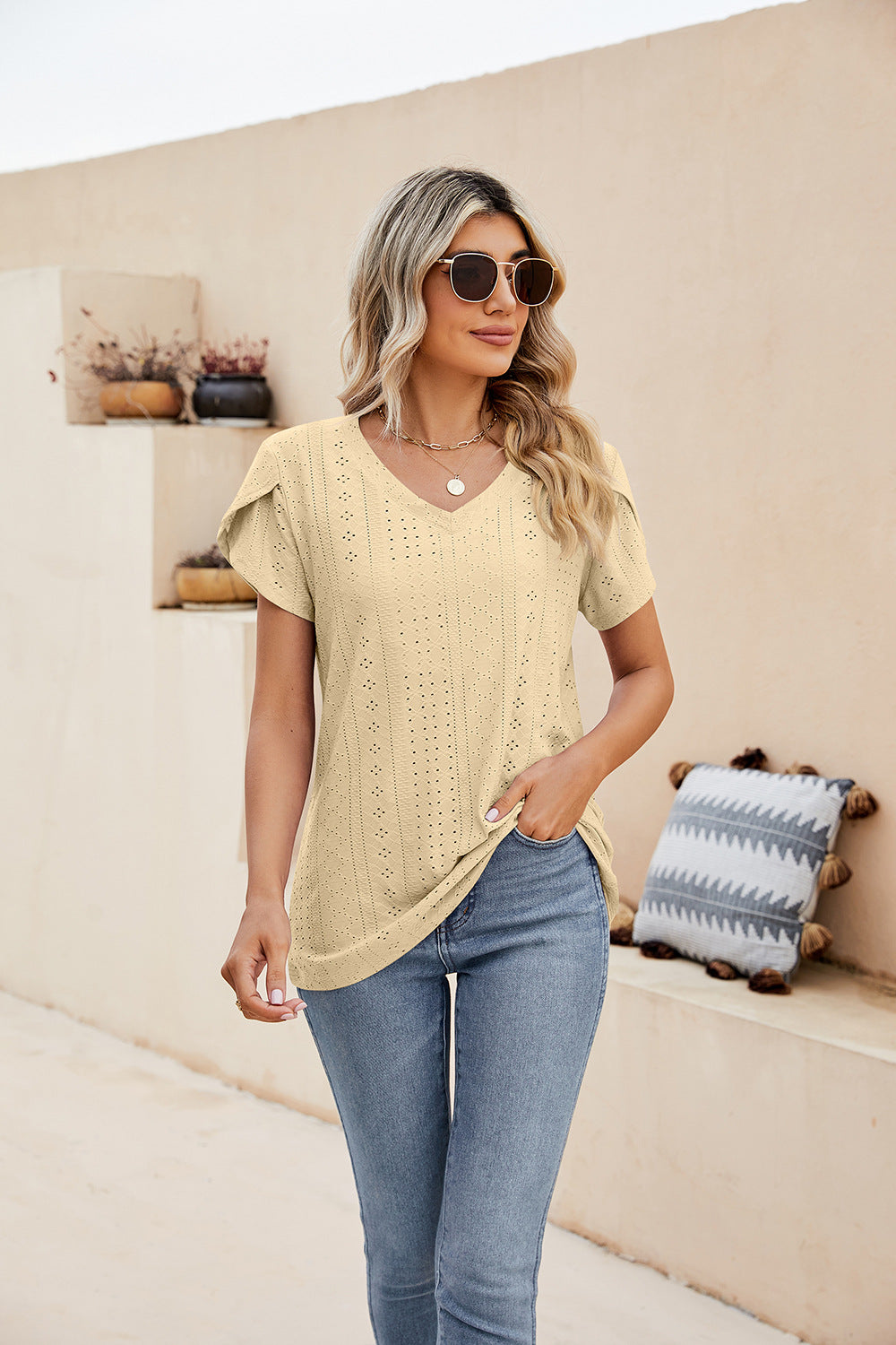 Light yellow knit top with v-neck and perforated sleeve detail
