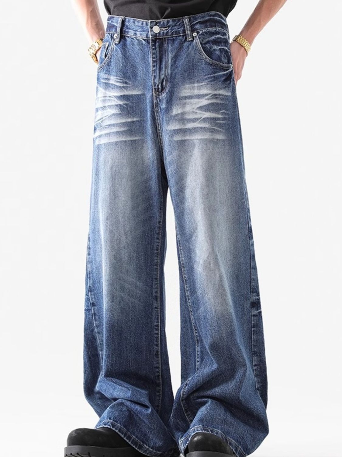 Relaxed fit washed blue denim jeans with whiskering detail.