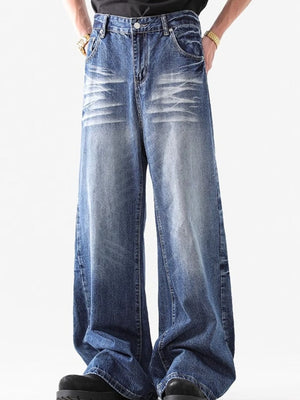 Relaxed fit washed blue denim jeans with whiskering detail.