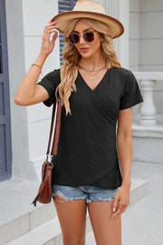Black eyelet wrap v-neck top with short sleeves and a textured pattern.
