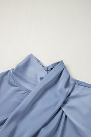 Dusty blue blouse with draped neckline and bell sleeves.