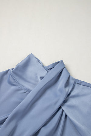 Dusty blue blouse with draped neckline and bell sleeves.