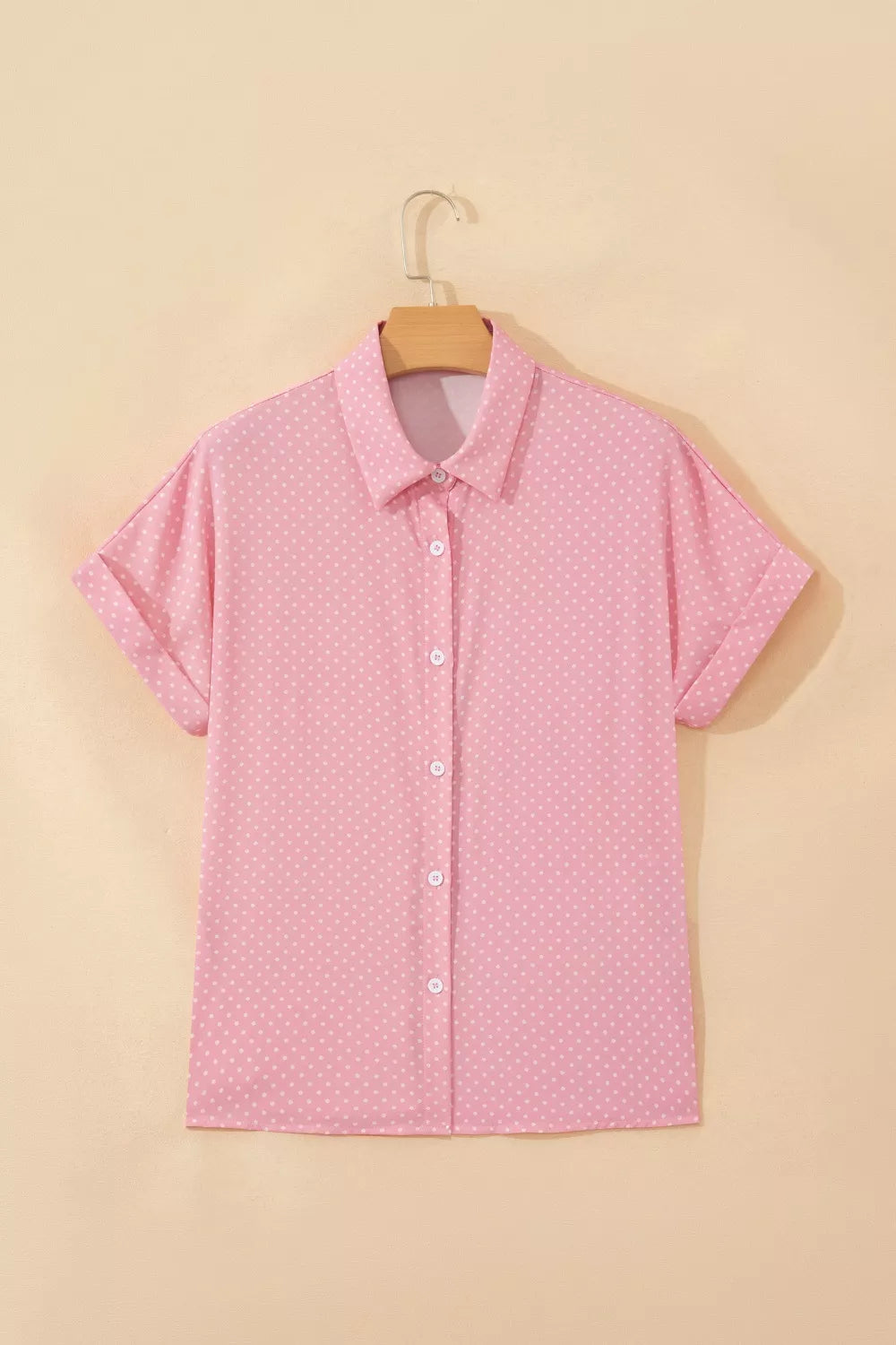 Pink polka dot button-up shirt with short sleeves and a collared neckline.