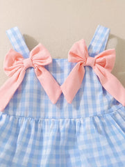 Blue gingham baby dress with pink bow shoulder straps and ruffled skirt.