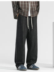 Men's black wide-leg jeans with drawstring and contrast stitching.