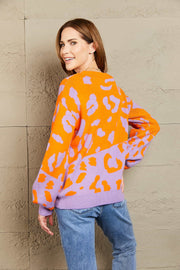 Colorblock leopard knit sweater with balloon sleeves in orange and lavender acrylic.