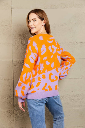 Colorblock leopard knit sweater with balloon sleeves in orange and lavender acrylic.