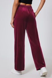 Burgundy velvet palazzo lounge trousers with a drawstring waist and wide leg.