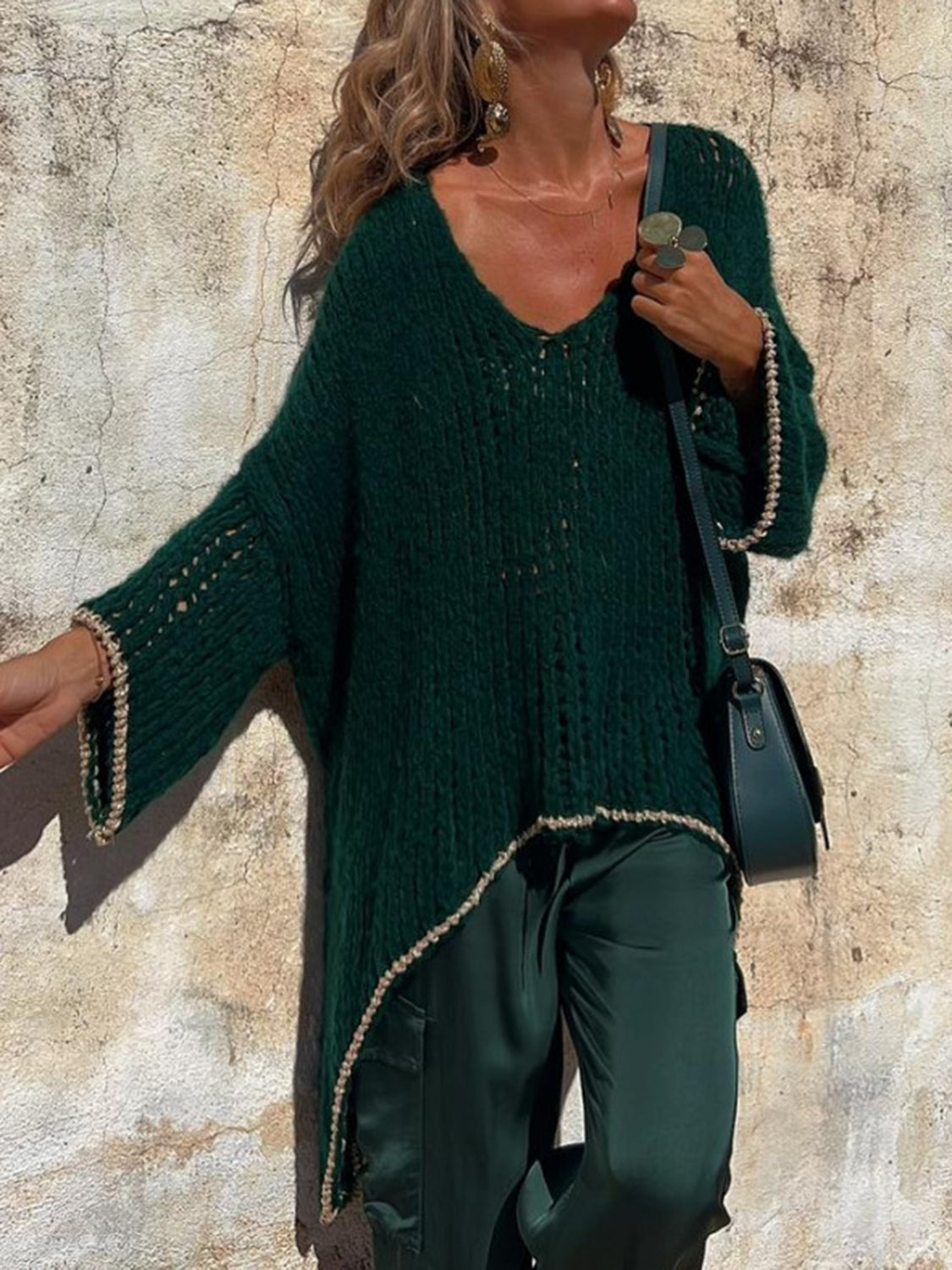 Dark green open knit sweater with asymmetric hem and beaded trim.