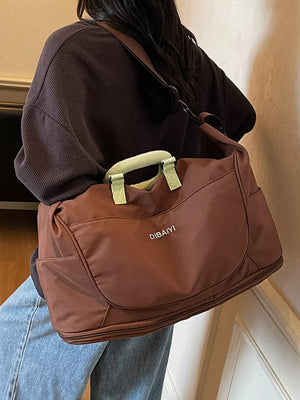 Brown Oxford cloth travel duffel bag with light green handles and side pockets.