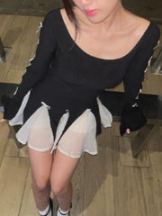 Black mini dress with long sleeves, scoop neck, and layered white skirt with bowknot details.