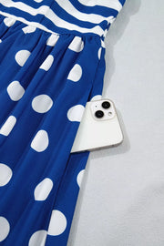 Maxi swim dress with blue and white polka dots and stripes, featuring a pocket holding a phone.
