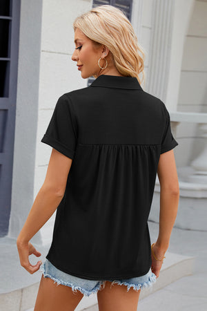 Black polo top with short cuffed sleeves and gathered yoke detail.