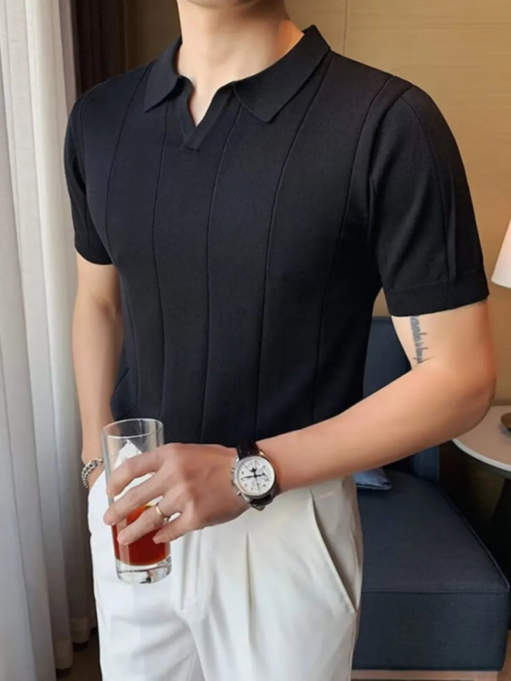 Black textured knit polo shirt with vertical ribbing and short sleeves.