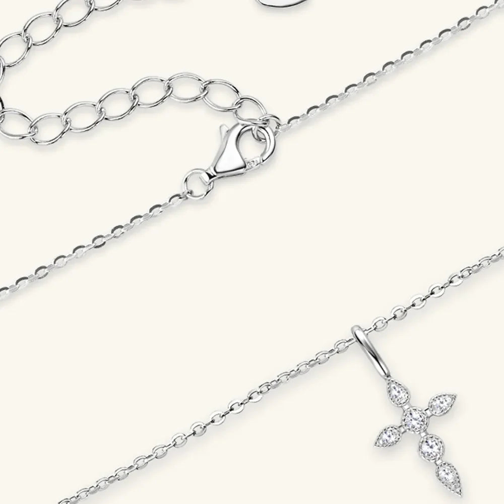 Silver pendant necklace with diamond-set cross and adjustable chain.