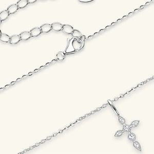 Silver pendant necklace with diamond-set cross and adjustable chain.