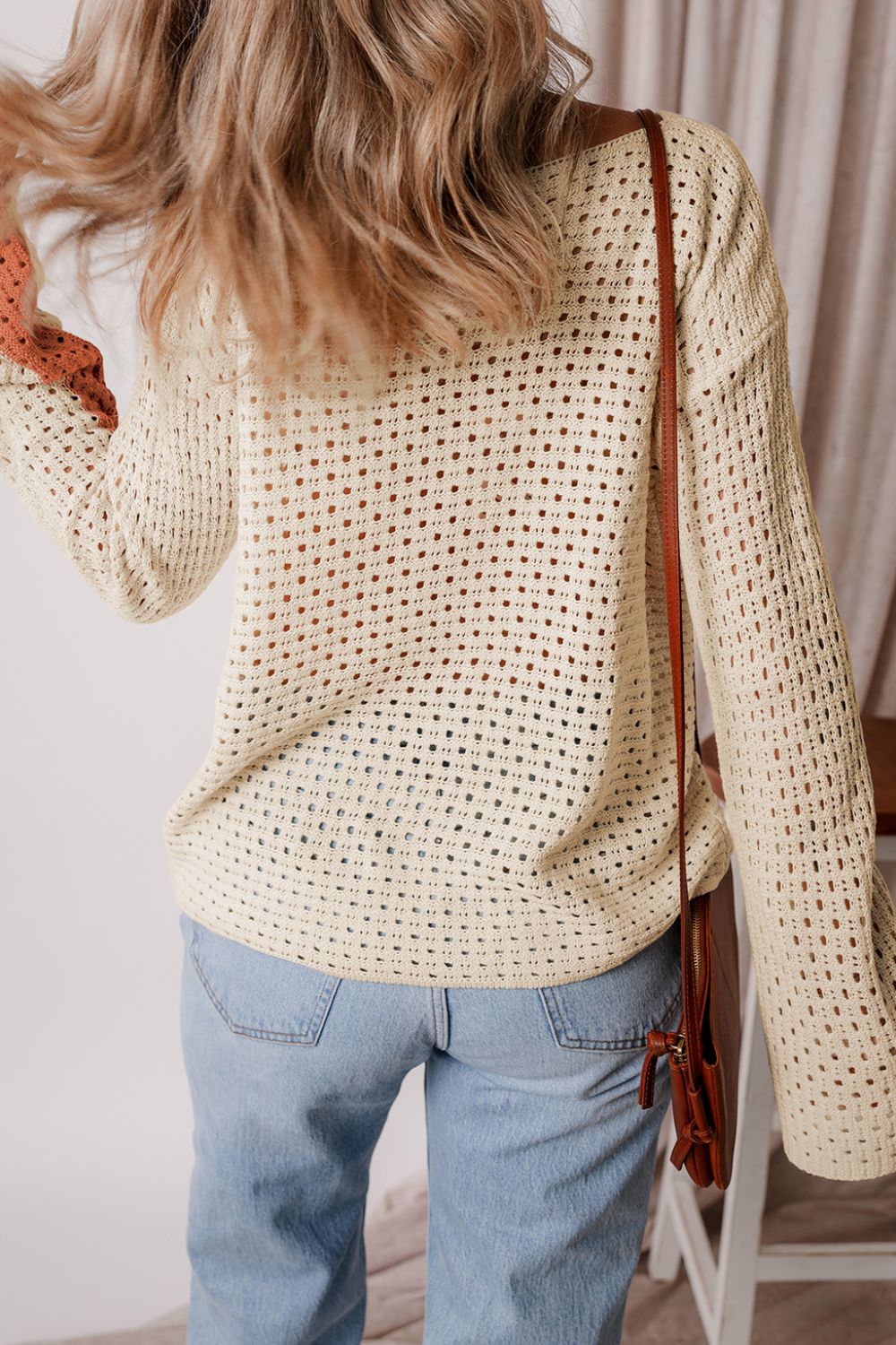 Beige crochet knit sweater with ombre sleeves, featuring an open knit pattern and a relaxed fit.