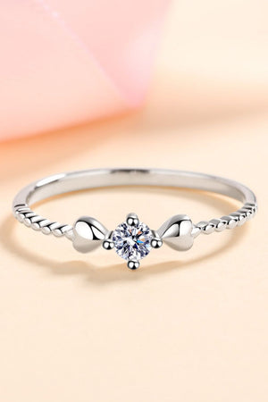 Silver ring with moissanite center stone and heart details