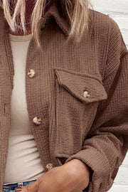 Brown corduroy utility jacket with button-flap chest pocket and button front.