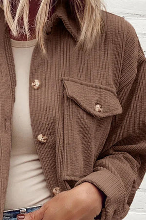 Brown corduroy utility jacket with button-flap chest pocket and button front.