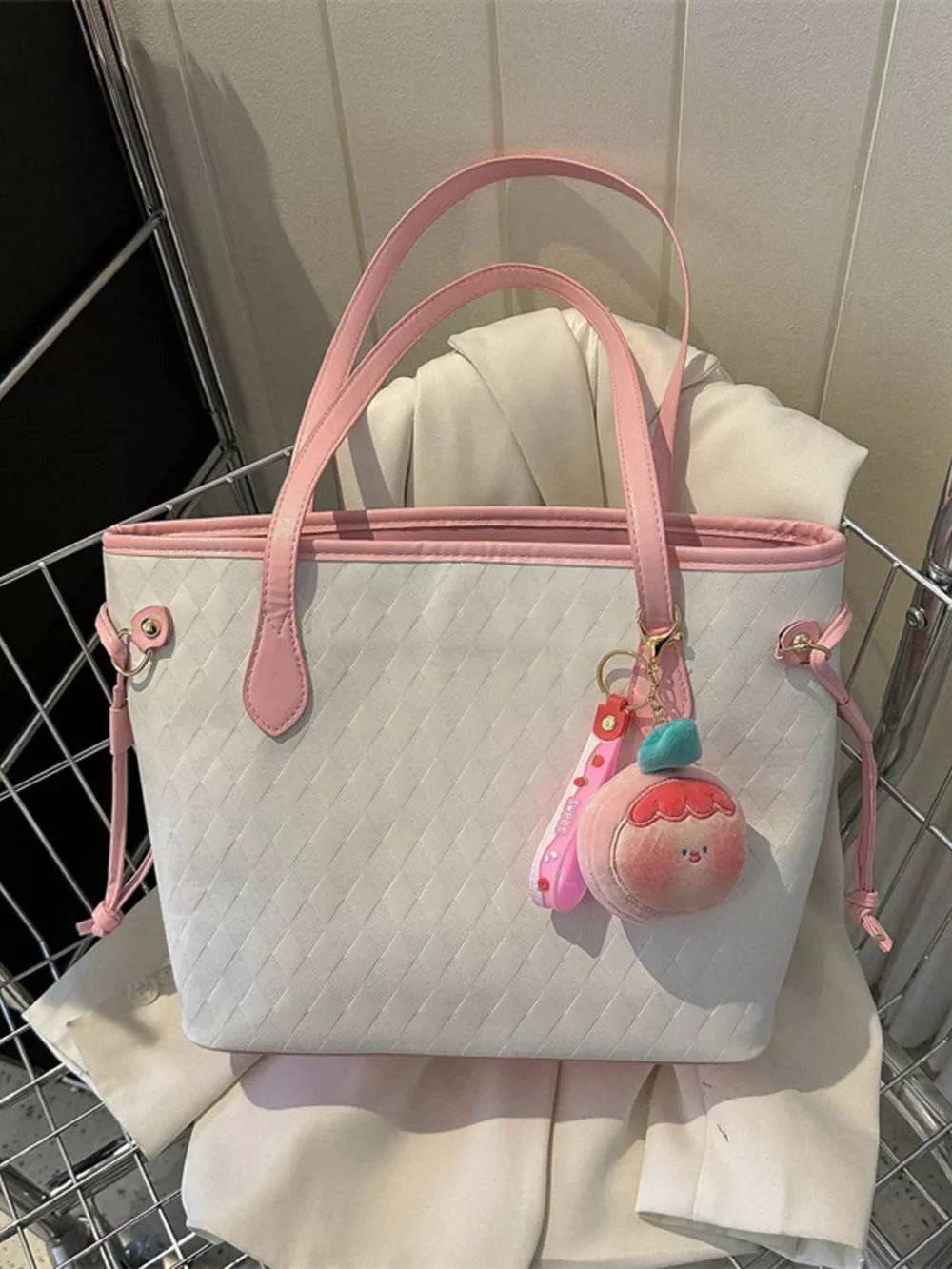 Textured diamond woven tote bag in white with pink trim and charm