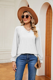 White perforated sleeve blouse with ruffle cuffs and v-neckline.