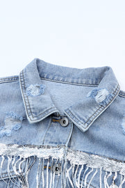 Medium wash denim trucker jacket with distressed details and sequin fringe trim.